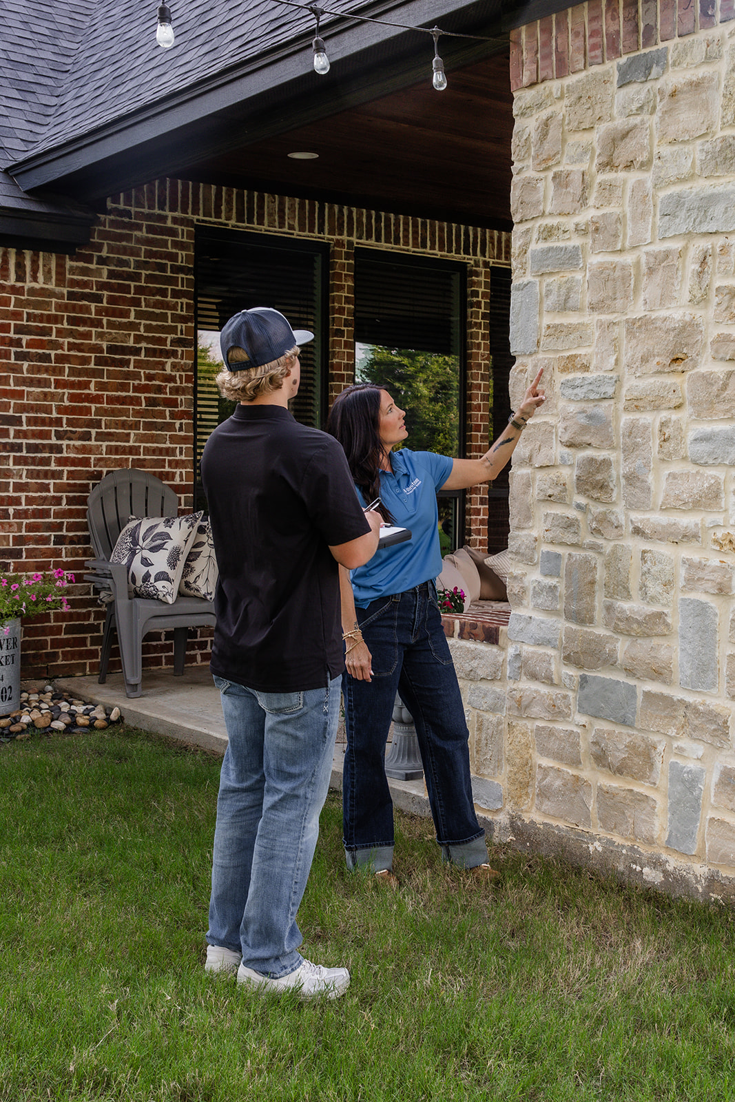 People inspecting stone house exterior
